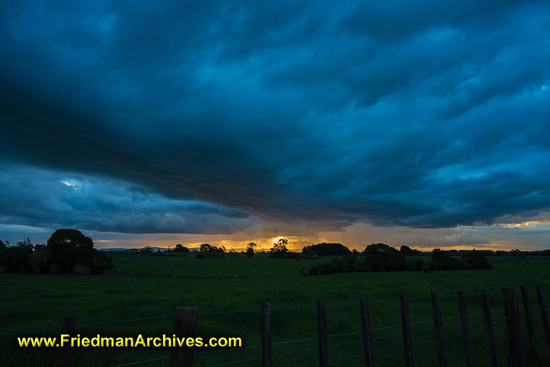 clouds,grey,blue,orange,sunset,sunrise,fence,field,landscape,postcard,